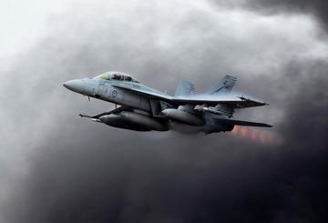 Jet with afterburner against dark clouds