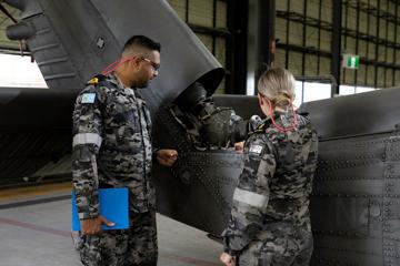 Two people inspecting a helicopter
